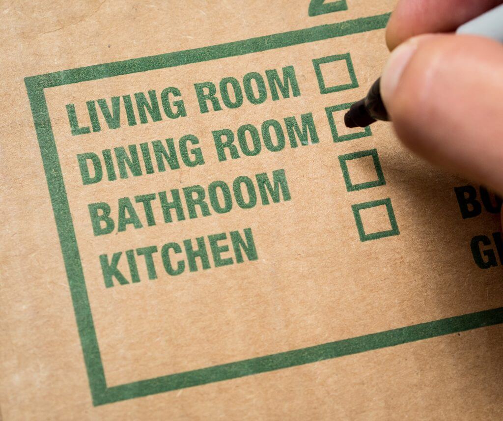 main avec marqueur sur le point de vérifier "salle à manger" boîte sur carton