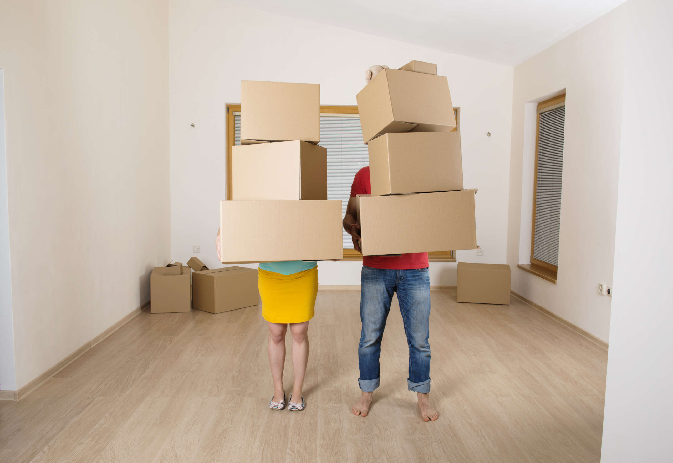 Un jeune couple emménage dans une nouvelle maison avec beaucoup de cartons.